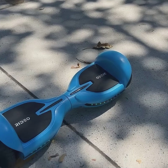 A man rides the Rideo Q3-C hoverboard along a park path, showcasing smooth movements and effortless control in a vibrant outdoor setting.