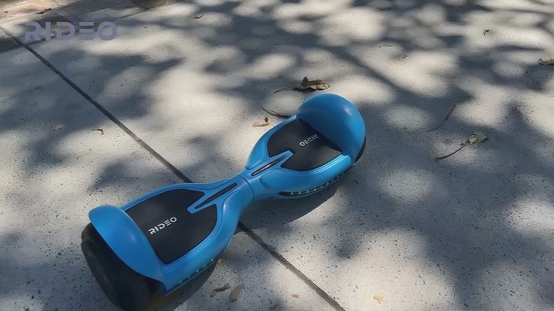 A man rides the Rideo Q3-C hoverboard along a park path, showcasing smooth movements and effortless control in a vibrant outdoor setting.